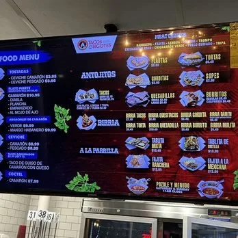 Tacos El Bigotes digital menu board listing tostadas, camarones, ceviche, coctel, antojitos and birria