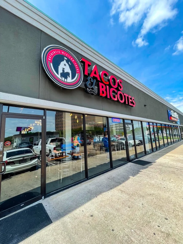 Tacos El Bigotes storefront with the red sign and glass front in Houston