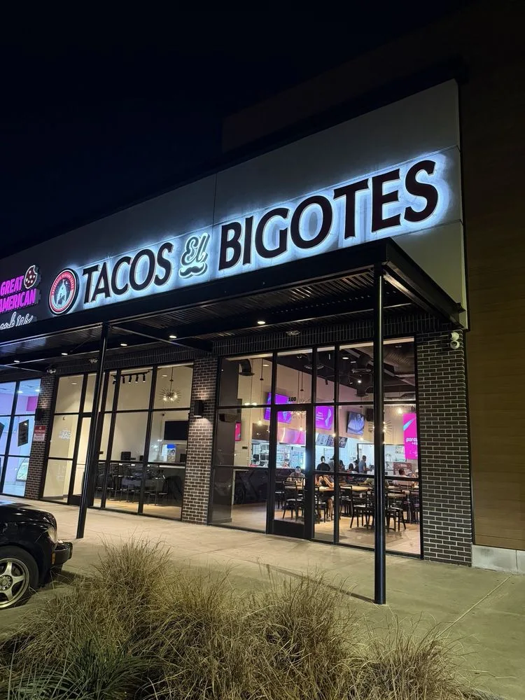 Tacos El Bigotes Tomball Pkwy storefront at night with the lit sign above Suite 100 in north Houston